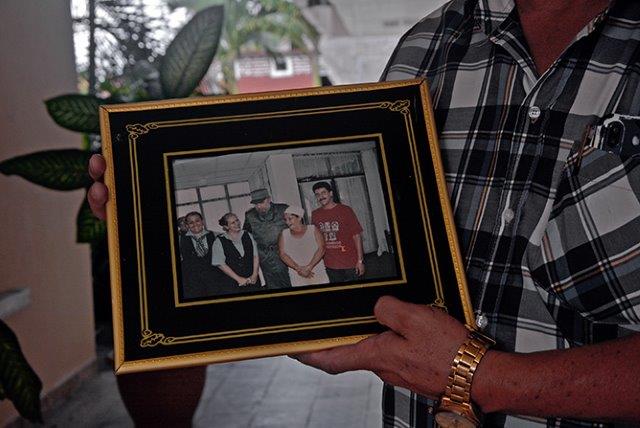 Moya sostiene cuadro con foto de Fidel junto a trabajadores del Hotel Los Jardines